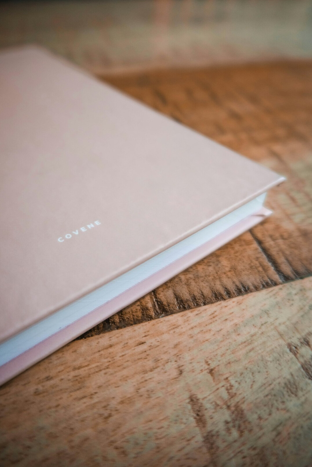 Open notebook with a pen resting on a wooden table